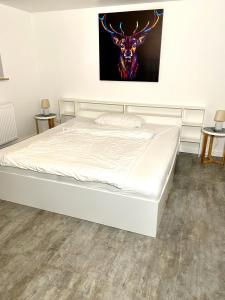 een bed in een slaapkamer met een foto van een hert bij Im Grünen von Kiel in Kiel