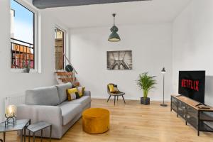 uma sala de estar com um sofá e uma mesa em Loft-Appartements mit Terrasse em Bremen