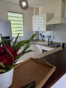 a kitchen with a vase of flowers on a table at Les Libellules in Les Trois-Îlets