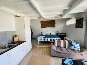 a living room with a couch and a bed at Muri Beach Studio with Pool in Rarotonga