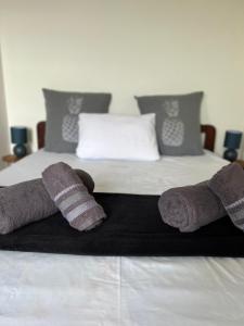 a bed with two mittens and towels on it at Les Libellules in Les Trois-Îlets