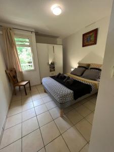 a bedroom with a bed and a chair in it at Les Libellules in Les Trois-Îlets