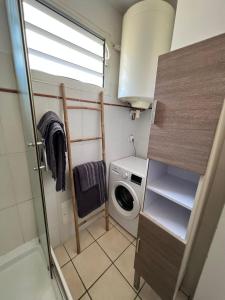 a small bathroom with a washing machine and a washer at Les Libellules in Les Trois-Îlets