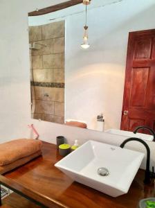 y baño con lavabo blanco sobre una mesa de madera. en Miah house, en Puerto Jiménez