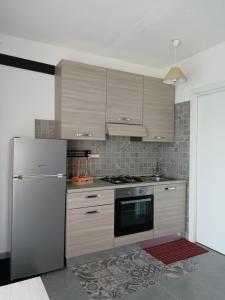 a kitchen with a refrigerator and a stove at Studio Apartment Residenza del Sole in La Maddalena