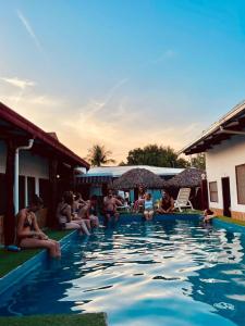 eine Gruppe von Menschen, die um einen Pool herum sitzen in der Unterkunft El Curichal Hostel in Rurrenabaque