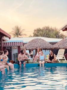 un grupo de personas sentadas en una piscina en El Curichal Hostel, en Rurrenabaque