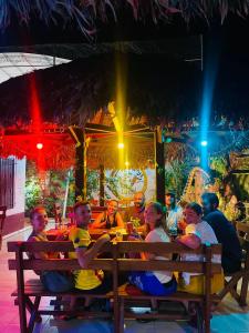 a group of people sitting on a bench in a restaurant at El Curichal Hostel in Rurrenabaque