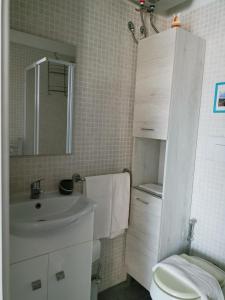 a bathroom with a sink and a toilet and a mirror at Studio Apartment Residenza del Sole in La Maddalena