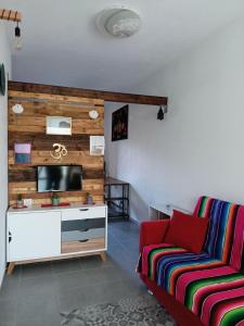 a living room with a couch and a tv at Studio Apartment Residenza del Sole in La Maddalena