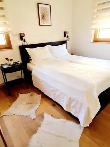 ein Schlafzimmer mit einem großen Bett mit weißer Bettwäsche in der Unterkunft Amber Gold Apartment in Zlatibor