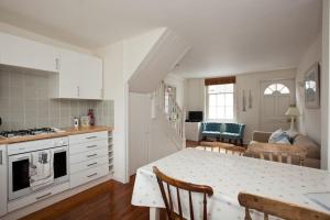 a kitchen and living room with a table and a dining room at Quaker Cottage in historic Arundel in Arundel