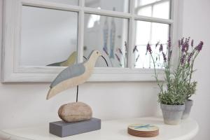 a bird statue sitting on a table next to a window at Quaker Cottage in historic Arundel in Arundel