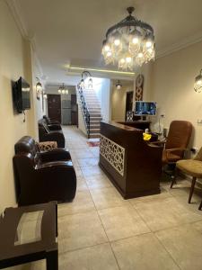 a living room with leather furniture and a chandelier at Bedouin Pyramids View in Cairo