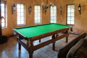 a living room with a pool table in a room at Hotel Nomad Belvedere Lodge in Midrand