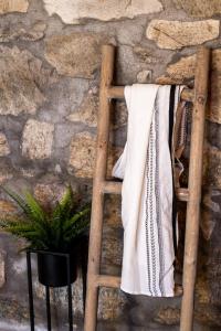 una escalera de madera apoyada en una pared de piedra con una toalla en Happy Apartments Mykonos, en Klouvas