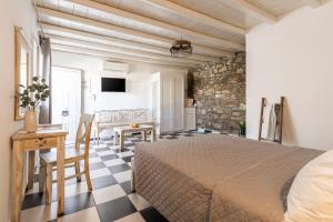 1 dormitorio con cama, mesa y escritorio en Happy Apartments Mykonos, en Klouvas