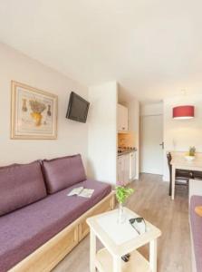 a living room with a purple couch and a table at Superbe Appartement à 50 m de la mer in Hyères