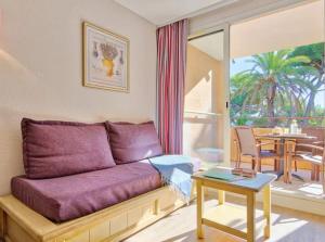 a living room with a purple couch and a table at Superbe Appartement à 50 m de la mer in Hyères