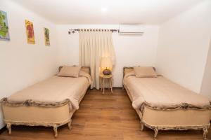 two beds in a room with a lamp on a table at Hotel Boutique Raíces de Colchagua in Santa Cruz +23 photos
