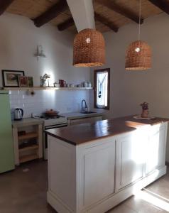 a kitchen with white cabinets and two pendant lights at mirapampa in Maimará