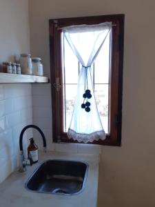 fregadero de cocina y ventana con cortina en mirapampa en Maimará