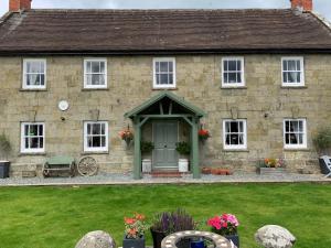 una casa de piedra con una puerta verde y un patio en Lodbourne House B&B en Gillingham