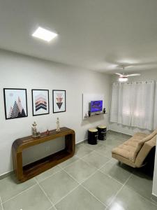 - un salon avec un canapé et une télévision dans l'établissement Apartamento Vista Mar - Marina, à Praia Grande