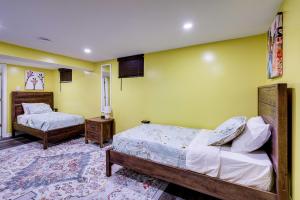 two beds in a room with yellow walls at Lovely 2 Bedroom, 2 Bath Unit in West Alexandria. in Alexandria
