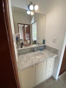 Un baño con lavabo y un espejo grande. en Alberdi Centro, en Tandil 23 fotos más