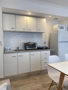 a kitchen with white cabinets and a refrigerator at Alberdi Centro in Tandil