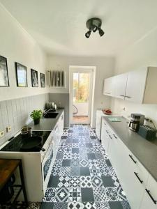 a kitchen with a black and white tile floor at Wunderschöne Altbauwohnung mit Balkon - 102 qm in Aachen