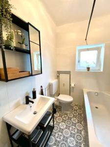 a bathroom with a sink and a toilet and a tub at Wunderschöne Altbauwohnung mit Balkon - 102 qm in Aachen