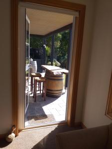 a sliding glass door leading to a patio with a table and a barrel at Rarangi Seaview On the Beach B&B in Blenheim