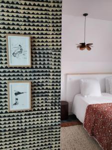 een slaapkamer met een muur met patronen naast een bed bij Maison Triton et Porcelaine in Saint-Coulomb