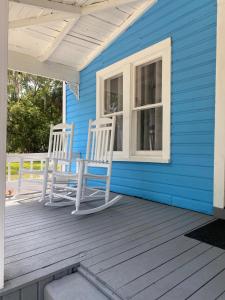 twee stoelen op de veranda van een blauw huis bij The Blue Aztec in Sanford