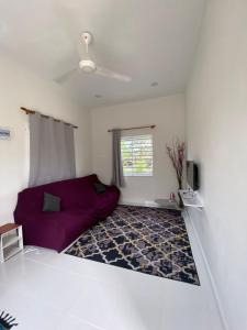 a living room with a purple couch and a window at Inap desa homestay batu buruk in Kuala Terengganu