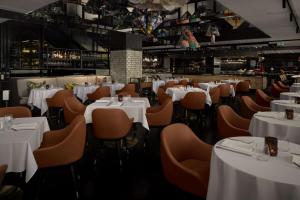 a dining room with white tables and chairs at QT Sydney in Sydney