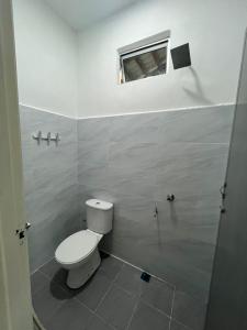 a bathroom with a toilet and a window at Inap desa homestay batu buruk in Kuala Terengganu +4 photos
