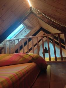 een bed op de zolder van een houten huis bij Chaleureuse maisonnette in Lopérec