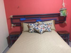 a bed in a room with a red wall at Casabella in Lucena