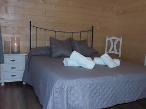 1 dormitorio con 1 cama con almohadas y silla en CABAÑA RURAL El MOLINO - Jacuzzi, en La Cimada
