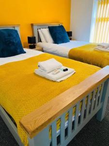 two beds with towels sitting on top of them at Bikers Grove Cottage in Troed-y-rhiw