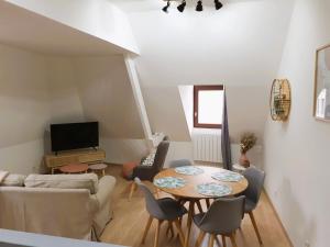 ein Wohnzimmer mit einem Tisch und einem Sofa in der Unterkunft Appartement 48m² / HyperCentre (Gares et Vieux Lille) in Lille