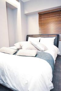 a bedroom with a bed with white sheets and pillows at Hotel Plaisir Akihabara in Tokyo