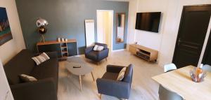 uma sala de estar com um sofá, cadeiras e uma mesa em Agréable T3 avec jardin et parking privé, à 350m du centre ville et des plages, wifi, remise supplémentaire de 10 pourcent pour une location à la semaine em Cavalaire-sur-Mer
