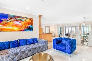 sala de estar con sofá azul y 2 sillas en 3BDR Villa-HeatedPool-6minFt.Lauderdale Beach-8PPL, en Fort Lauderdale