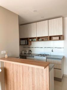 uma cozinha com armários de madeira e uma bancada em Hermoso departamento nuevo en Bahía Blanca piso 4 em Bahía Blanca