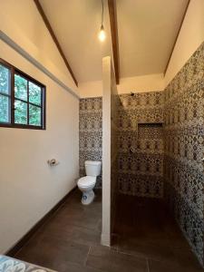 a bathroom with a toilet in a room at Café Madame in Puerto López