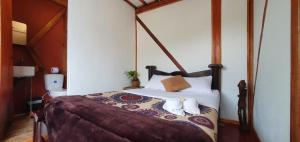 a bedroom with a bed with two towels on it at Kimaná Hostal in Santa Rosa de Cabal